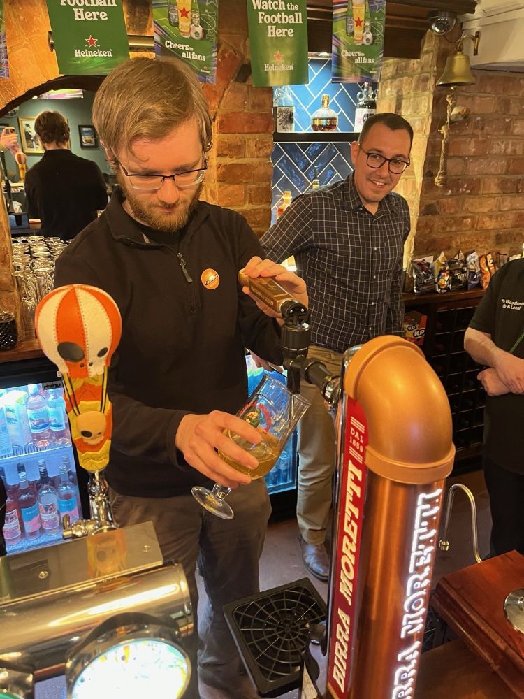 Andrew pulling a pint as Tom watches