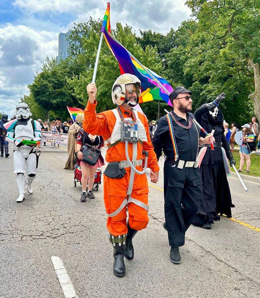 Rebel Pilot and Imperial Crewman holding hands during a Pride parade. Love really can bloom on the battlefield.