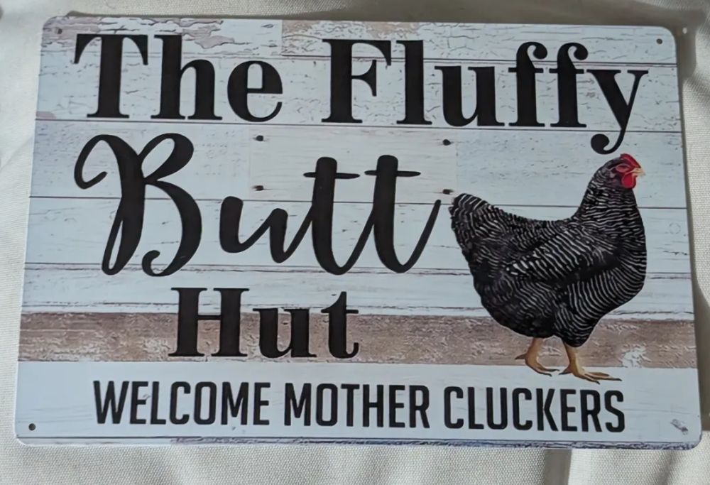 Sign that says: "The Fluffy Butt Hut Welcome Mother Cluckers"
the artwork on it is all generated by AI and has numerous errors such as a nonsensical feather pattern on a hen