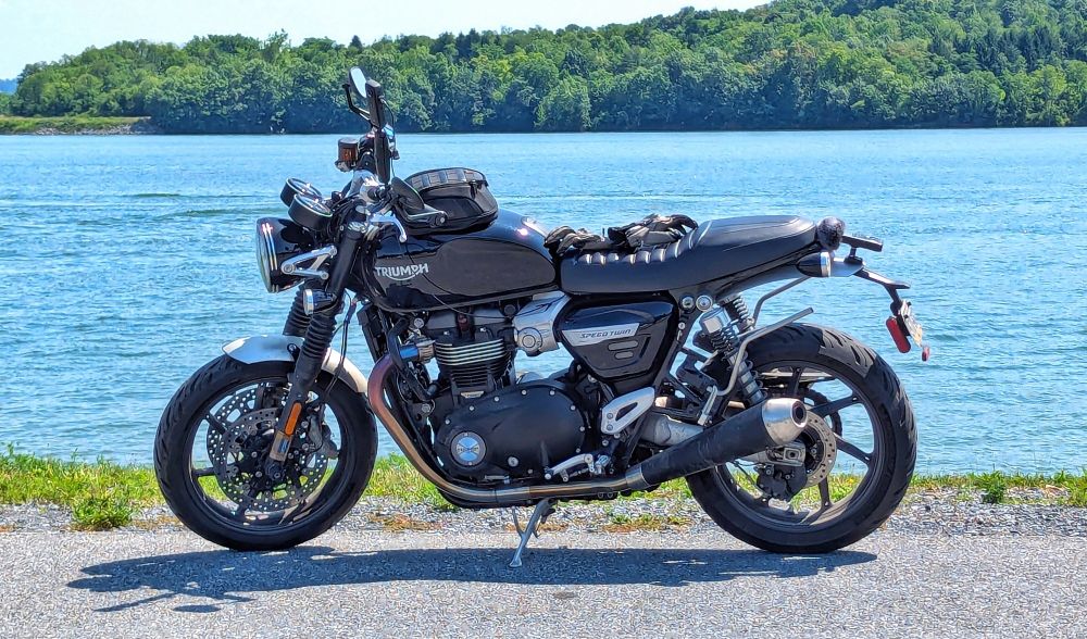 A black motorcycle with a lake in the background.