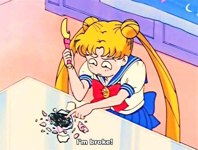 Usagi Tsukino saying "I'm broke!'" while smashing open a piggy bank on a white table only to see a small amount of coins.