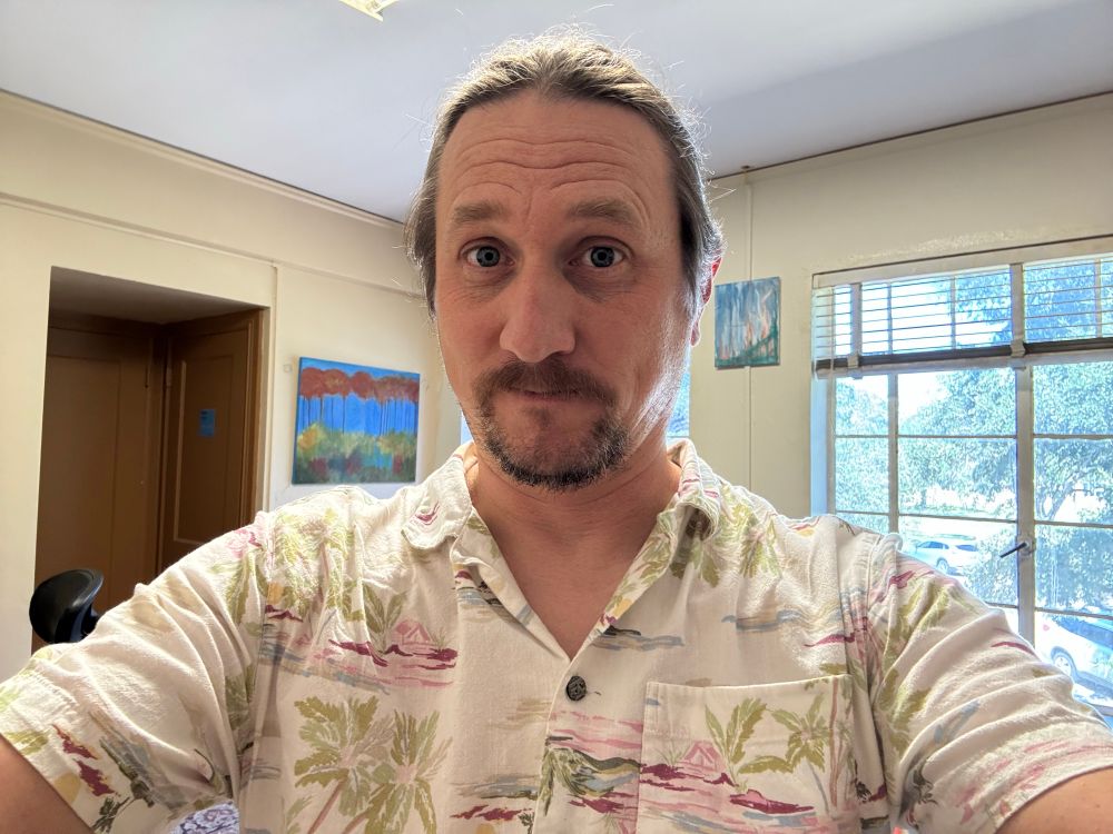 Me in my office, standing in front of the window 