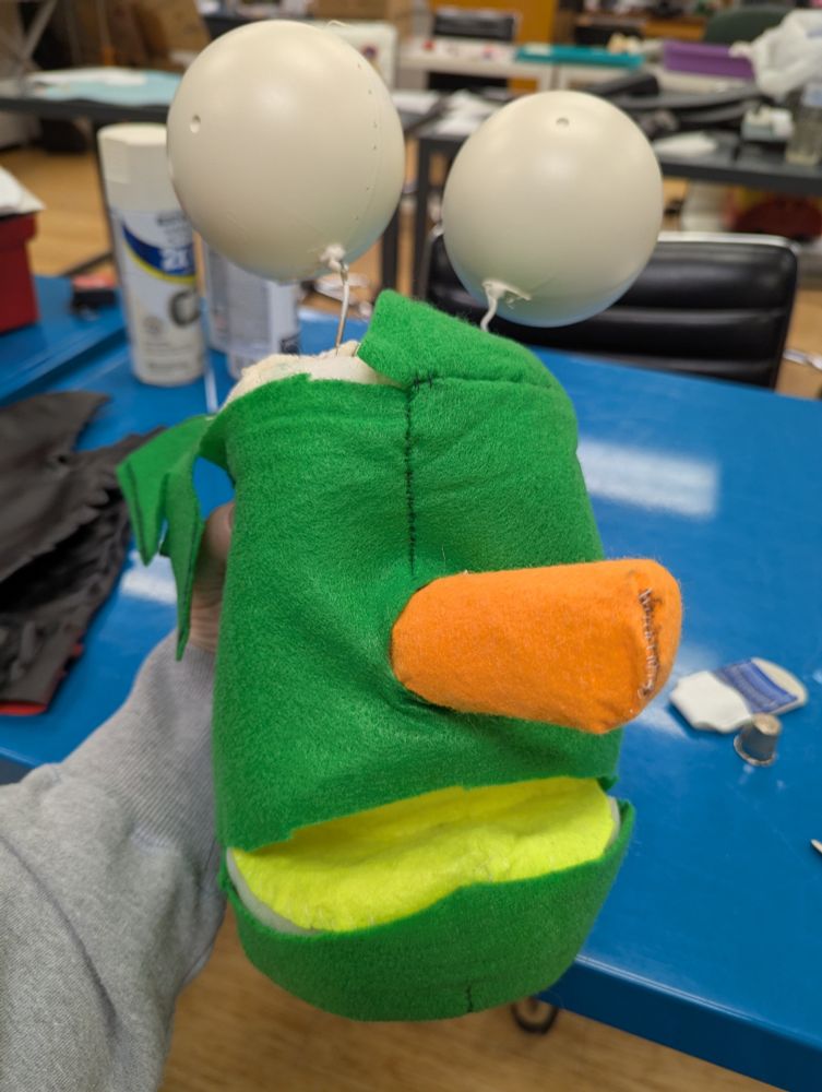 A strange assortment of fabric, foam, and capsule containers that resemble a half baked puppet.