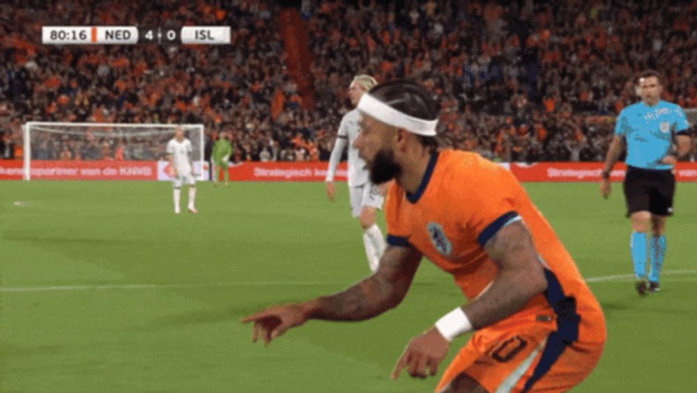 a soccer player wearing a headband is pointing at the camera during a game between netherlands and isl