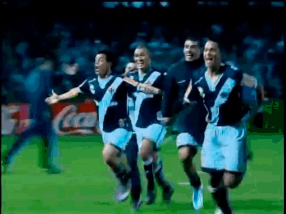 a group of soccer players are running on a field in front of a coca cola ad