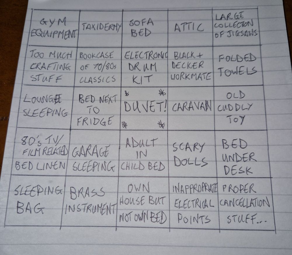 A five by five grid drawn on a pad, like a classic bingo card.
Top row: gym equipment, taxidermy, sofa bed, attic, large collection of jigsaws
Second row: too much crafting stuff, bookcase of 70s/80s classics, electronic drum kit, black & decker workmate, folded towels
Middle row: lounge sleeping, bed next to fridge, *DUVET*, caravan, old cuddly toy
Fourth row: 80s tv/film-related bed linen, garage sleeping, adult in child bed, scary dolls, bed under desk
Bottom row: sleeping bag, brass instrument, own house but not own bed, inappropriate electrical points, Proper Cancellation Stuff...