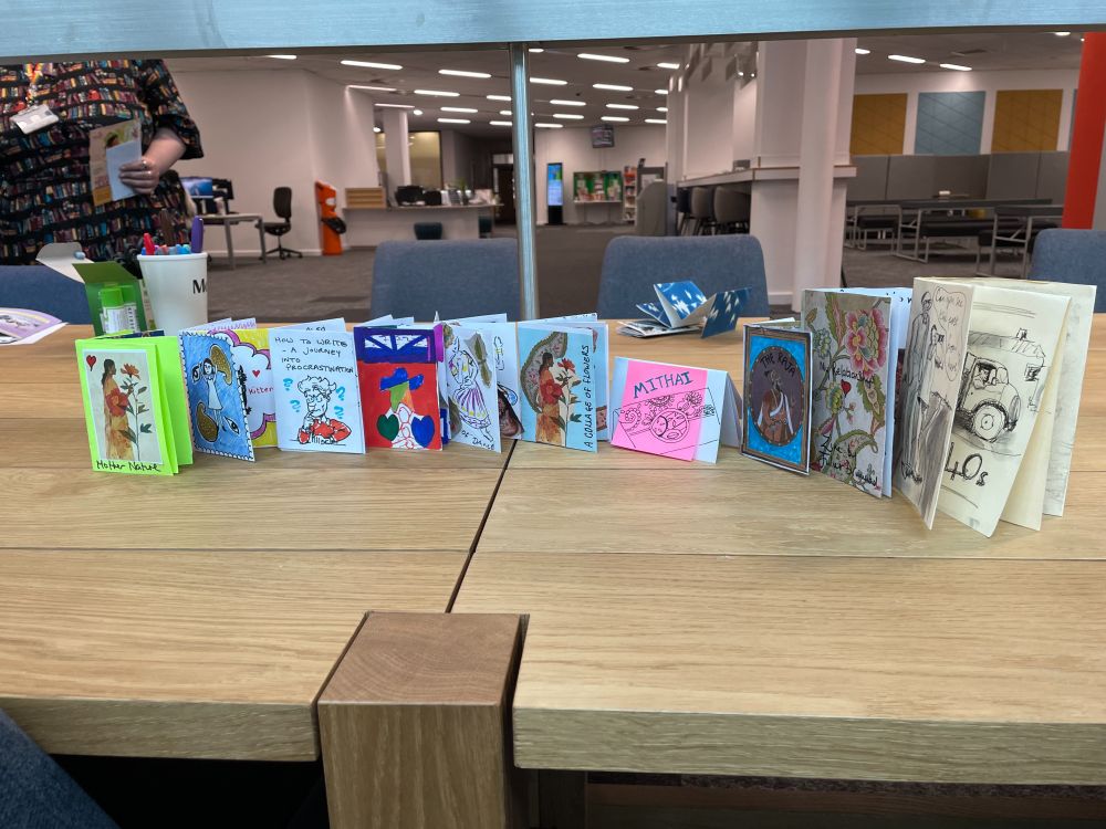 A photo of 10 homemade zines stood on the table