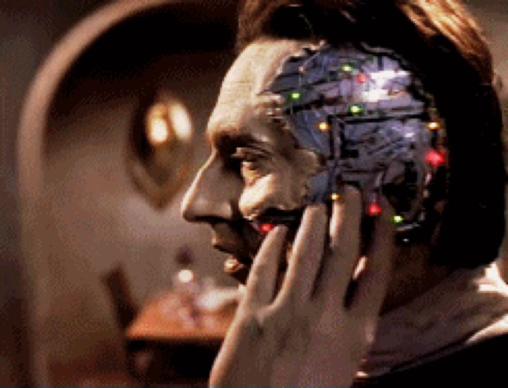 a man talking on a cell phone with a robotic face