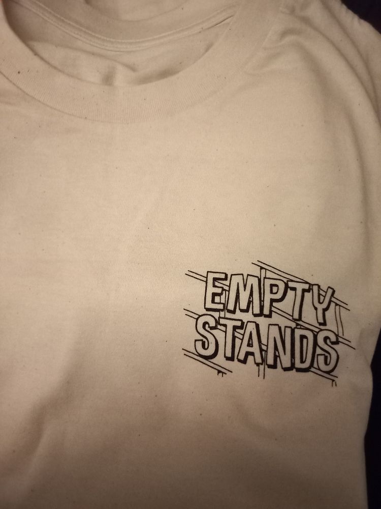 Man sieht ein weißes T Shirt mit dem Aufdruck "empty stands" auf der Brust. 
