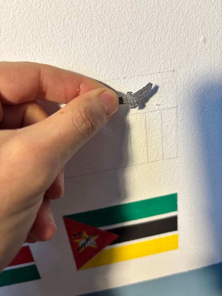The beginning of the flag of Zambia in pencil, with the cutout of an eagle used to trace it on the wall