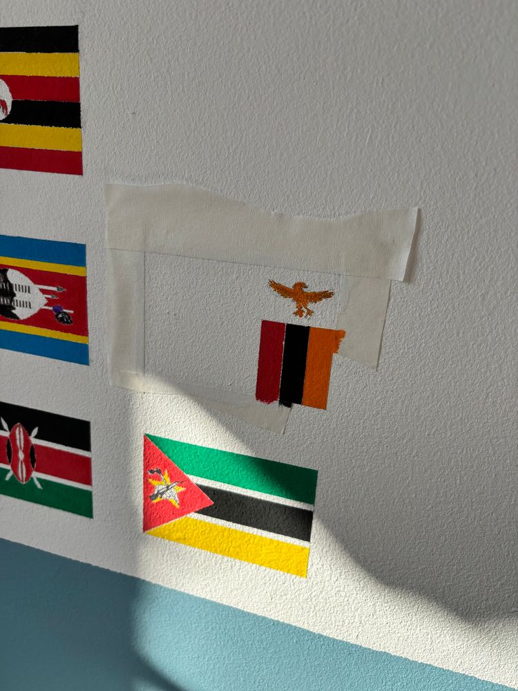 Partially-painted flag of Zambia, above the flag of Mozambique