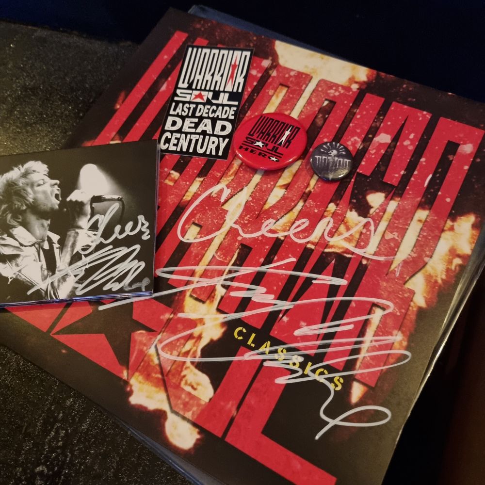 A variety of Warrior Soul merch, including CD, Record, badges and sticker