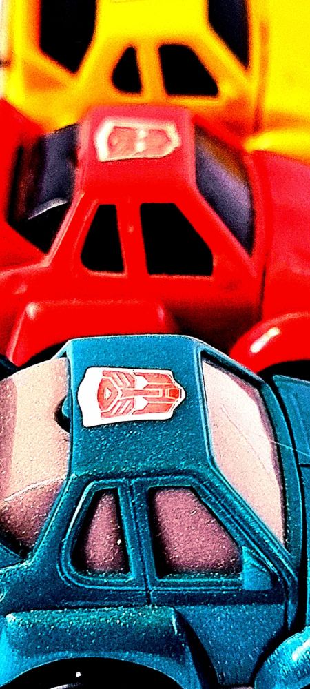 Close up on a hyper-saturated image of three colours of the Cliffjumper mould