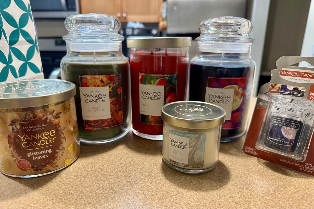 a collection of yankee candles: glistening leaves, crisp forest air, fall night, clean cotton, and then a 3-pack of car fresheners in midsummer’s night, leather, and new car smell