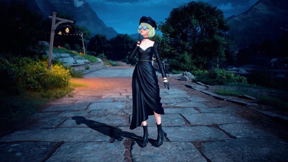 Nikki wearing a black dress with a short green bob and boots