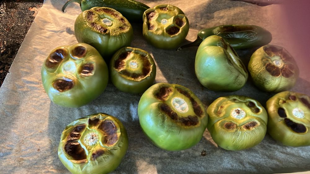 Image of roasted tomatillos and jalapeños. All green in color.