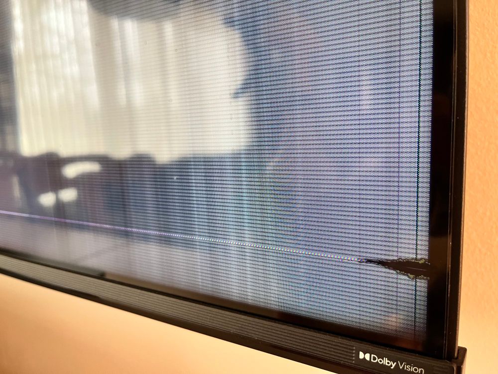 Picture showing a flatscreen TV with a broken screen. A small crack bleeding LCD nonsense can be seen in the bottom right corner