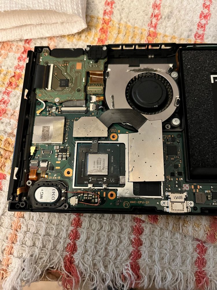 The back of a Nintendo Switch showing the internal components. A mod chip is soldered to the board.