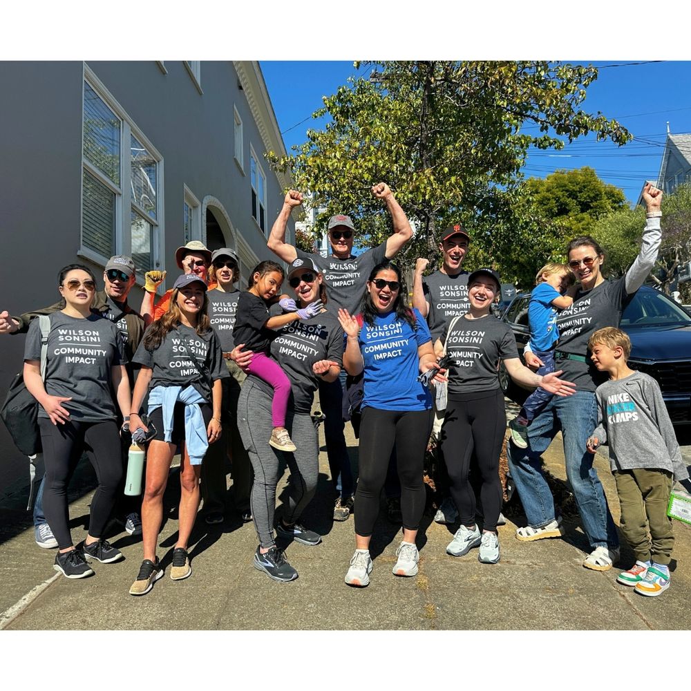 Group photo of fourteen adults and children who helped plant the sidewalk gardens.
