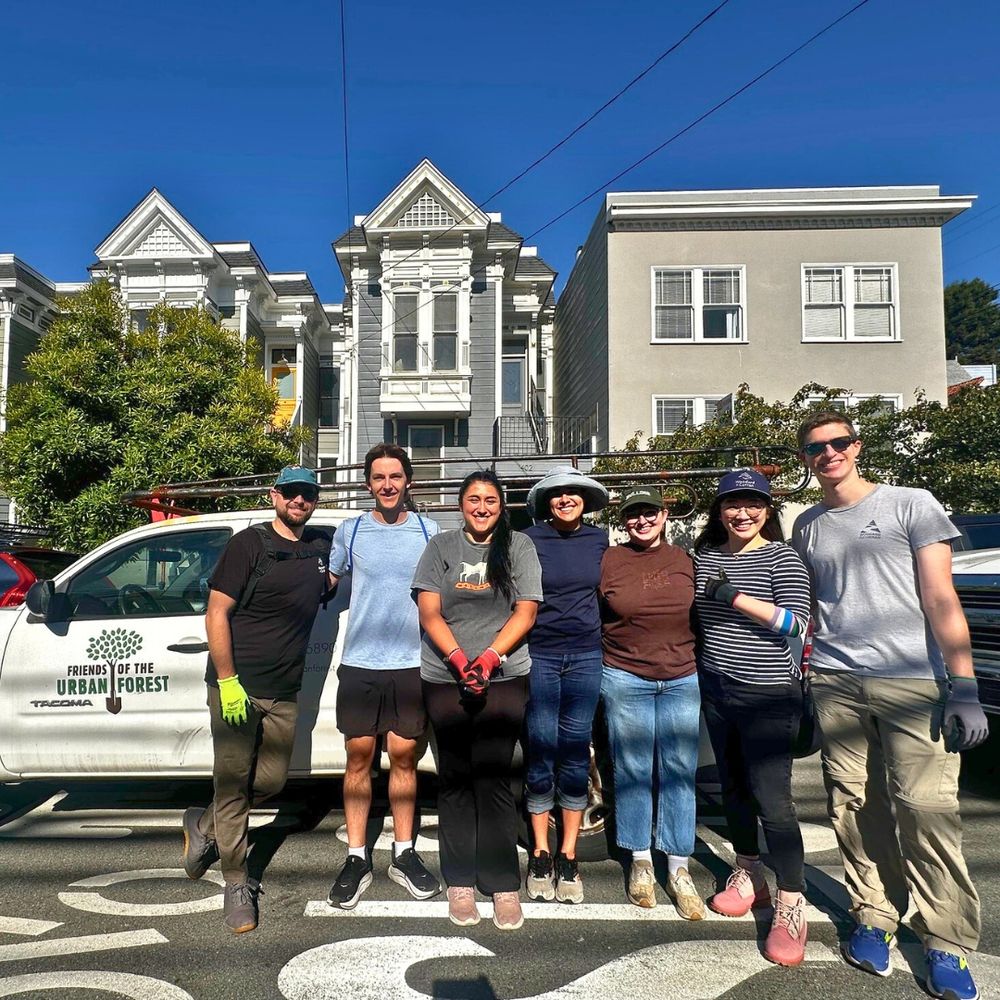 Group photo of seven smiling people who helped prep the sidewalk gardens
