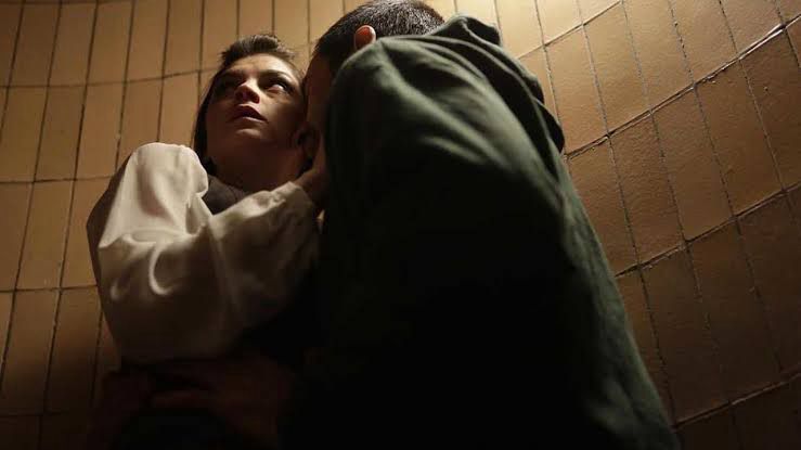 Homem com rosto encostado no pescoço de uma mulher que está olhando pra cima