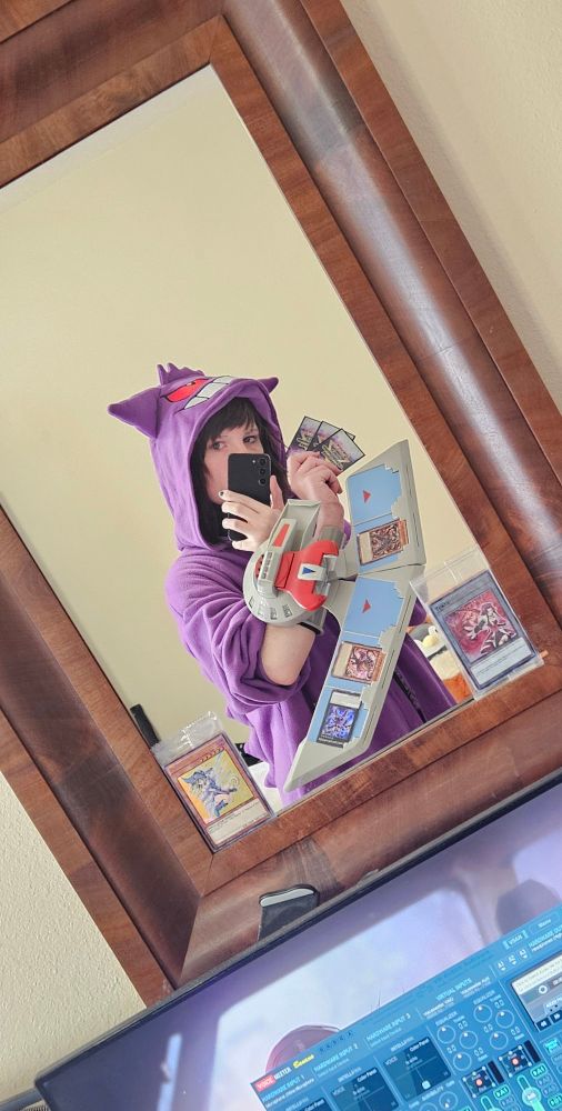 Cherri wearing a gengar onsie and a duel disk reflected in a *clean mirror*