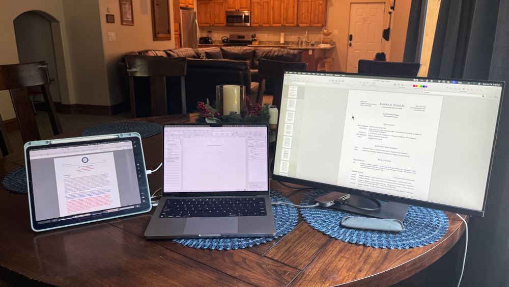 A laptop, external monitor, and iPad into a three-monitor setup. At a kitchen table at a nice Airbnb. 