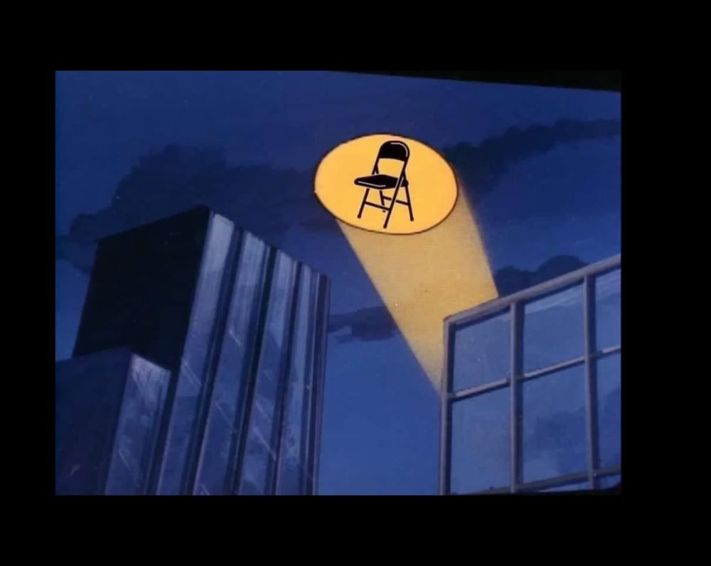The Bat signal over a city at night, changed to a folding chair signal. Alabama Brawl 23.