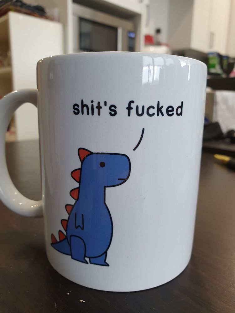 "Shit's fucked" dinosaur mug