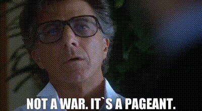 Gif from “Wag The Dog.” Dustin Hoffman listens to a man say “not a war. It’s a pageant.” .