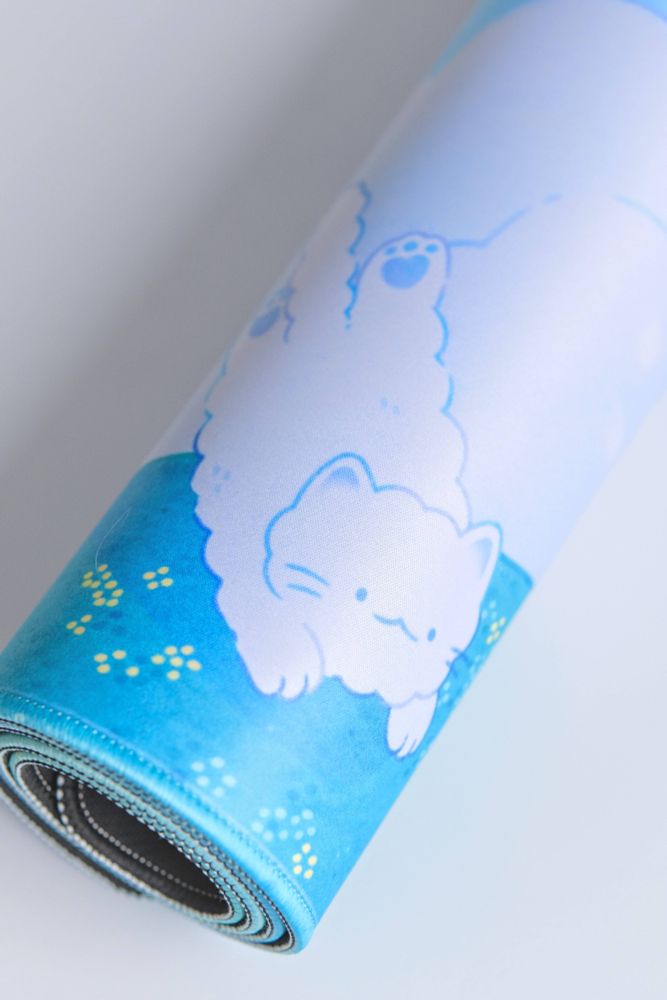 Photo of a rolled up desk mat. In the image you are zoomed in on an illustrated detail of a cloud in the shape of a cat.