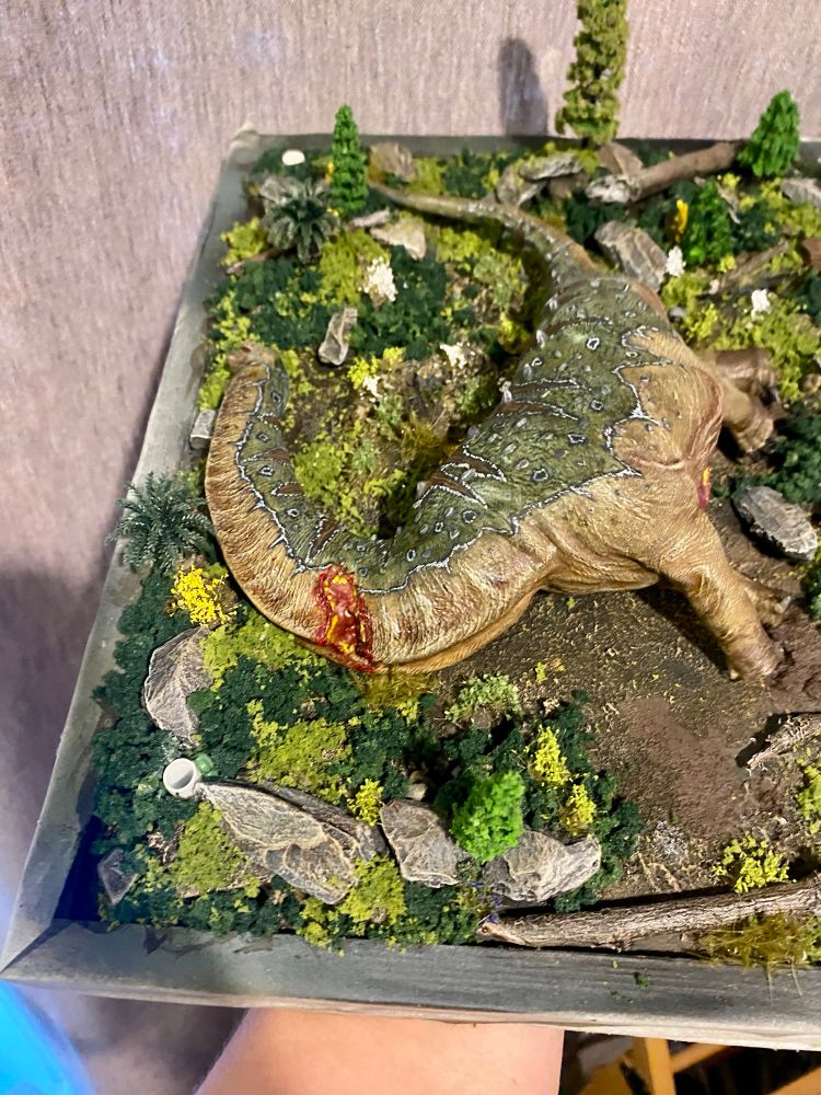 Fallen Sauropod on a verdant forest display base, note the white sockets for attaching trees 