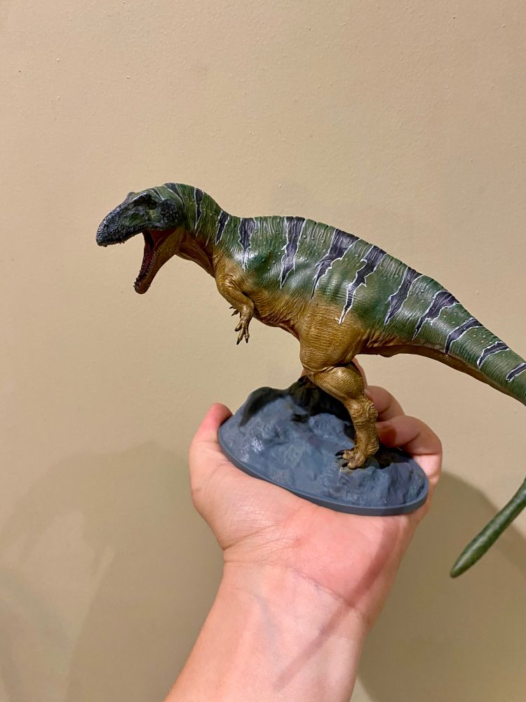 3D printed theropod painted up in green and ochre with black stripes 