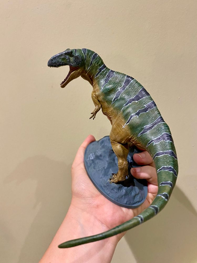 3D printed theropod painted up in green and ochre with black stripes 