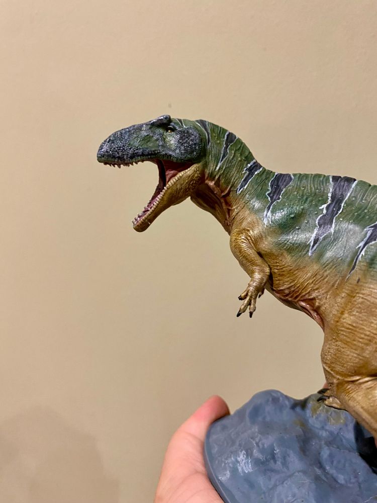 3D printed theropod painted up in green and ochre with black stripes 