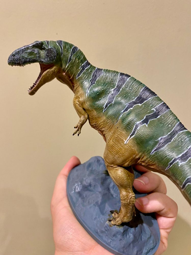3D printed theropod painted up in green and ochre with black stripes 