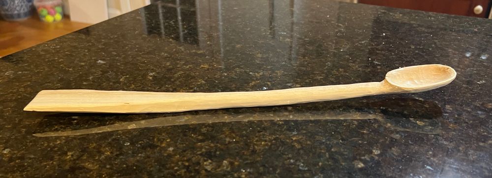 A long-handled wooden spoon with a small spatula on the other end. 