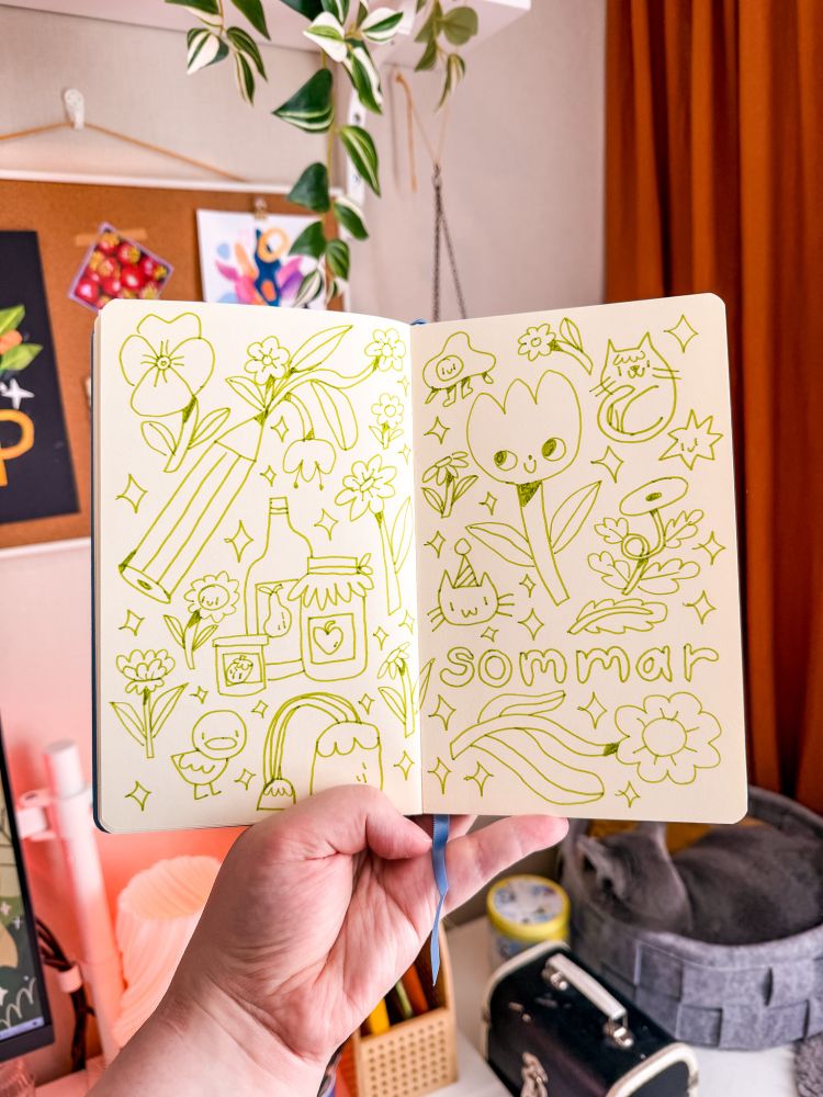 A photo of a sketchbook being held open. Inside are doodles in light green pen, featuring flowers, jars of jam, a pencil, a duck and the word "sommar" (which is summer in swedish).
