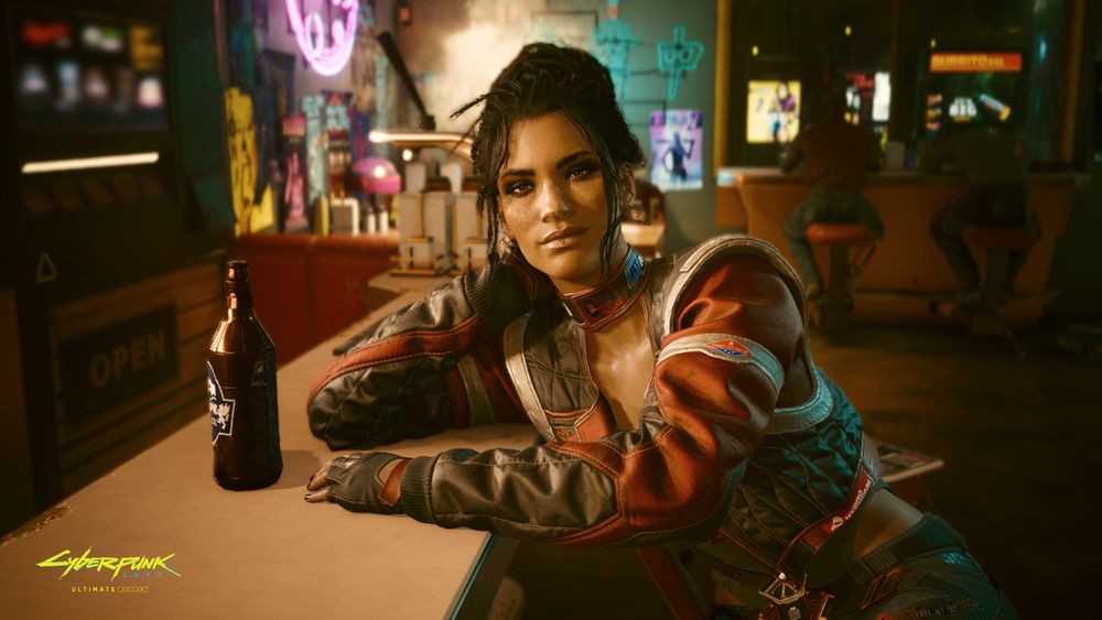 Screenshot of Cyberpunk 2077 Ultimate Edition on Nintendo Switch 2 shows Panam Palmer leaning on a bar, resting her head on her hand and smiling slyly.