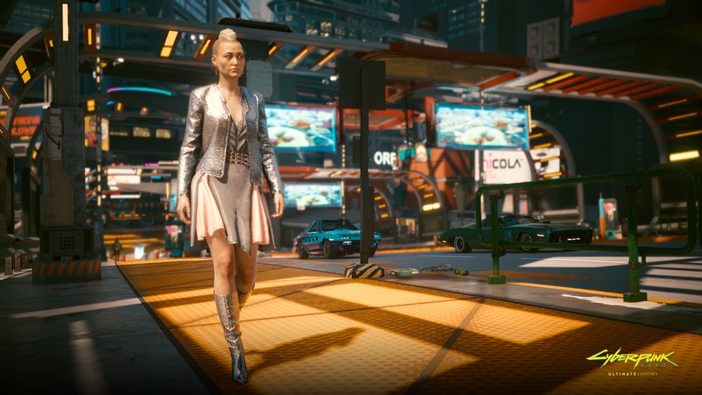 Screenshot of Cyberpunk 2077 Ultimate Edition on Nintendo Switch 2 shows the streets of Night City, with two cars in the background, and a woman with a blonde mohawk walking on the sidewalk.