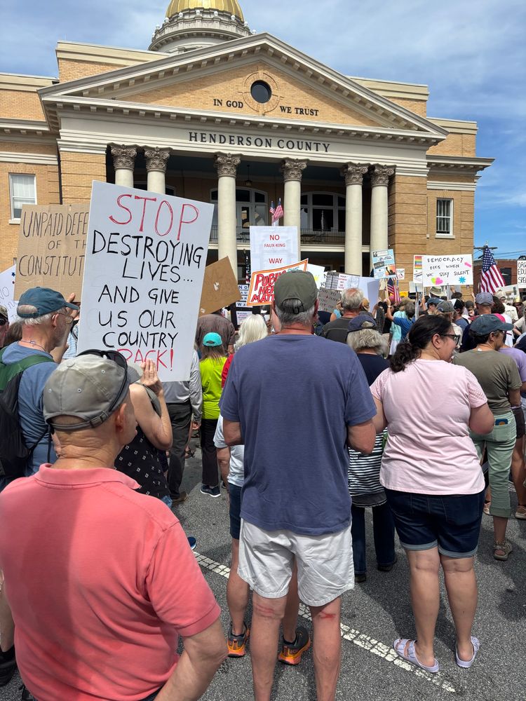 Crowd with signs at protest rally. 