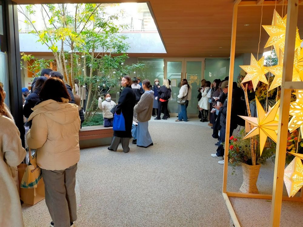 People, mostly young women, line up to eat at a restaurant
