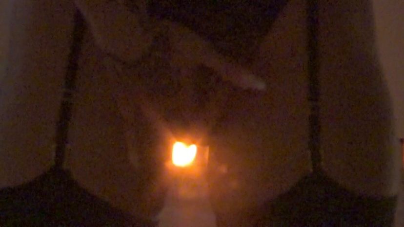 4 of 4: The final grainy screencap of Mistress Sky filming herself in the mirror with a camcorder. Tightly framed from the top of her pubic area to her upper thighs, the camera is out of shot. She is wearing a leopard print thong and the black straps of her garter belt descend from the top of the frame to meet the black holdups of her nylons. Mistress Sky stands with her legs slightly parted which reveals a warm glowing light source behind her, creating the illusion that the source of light comes from between her legs. Her tattooed left hand is seen taking a dive towards the light, her pinky and thumb taking rest on her inner thighs. Femdom. Prodomme. Dominatrix. Goddess. 