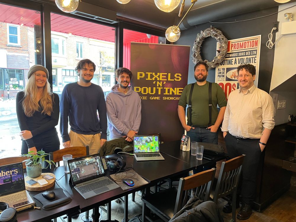 Five indie game developers standing around tables with three laptop game demos and a banner saying Pixels N Poutine