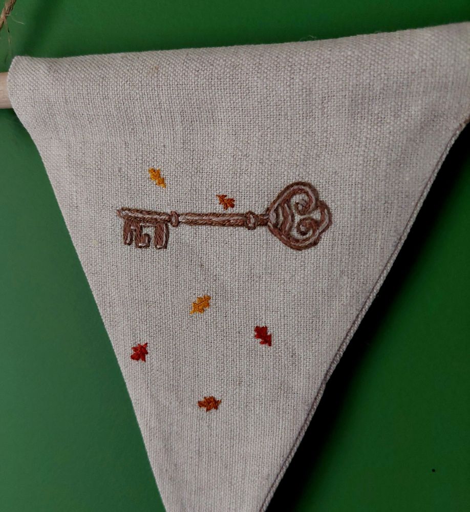 Gros plan sur la broderie de clef avec de petites feuilles de chêne. 