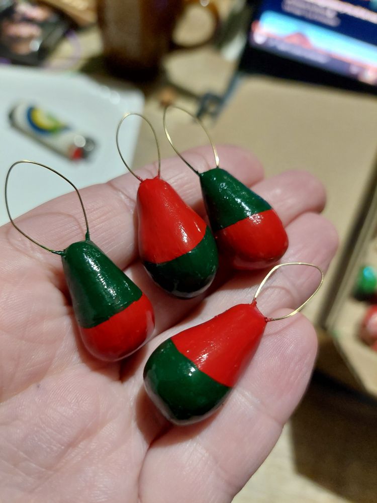 Dos des matriochkas rouge et verte posées dans une main. On voit qu'elles sont vernies.