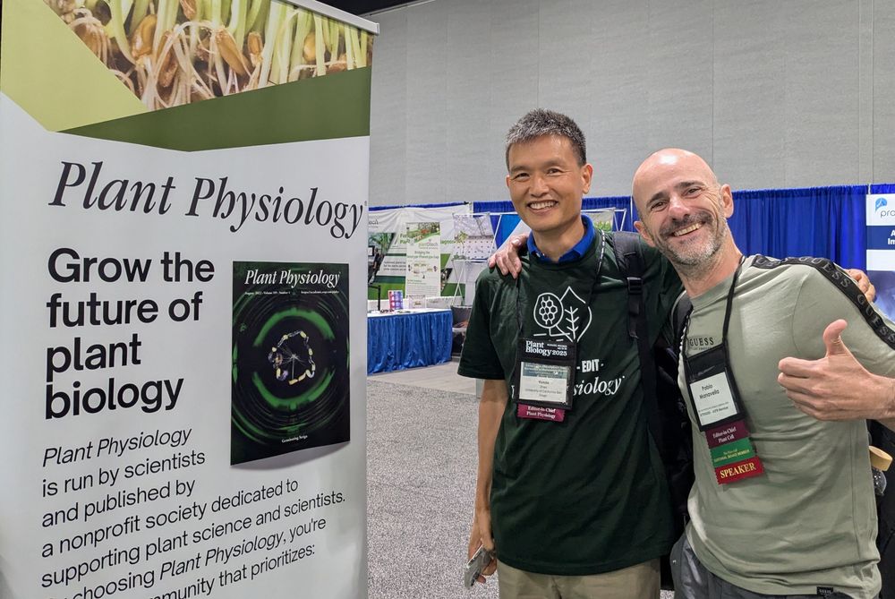 Yunde and Pablo smiling in front of a Plant Physiology poster. 