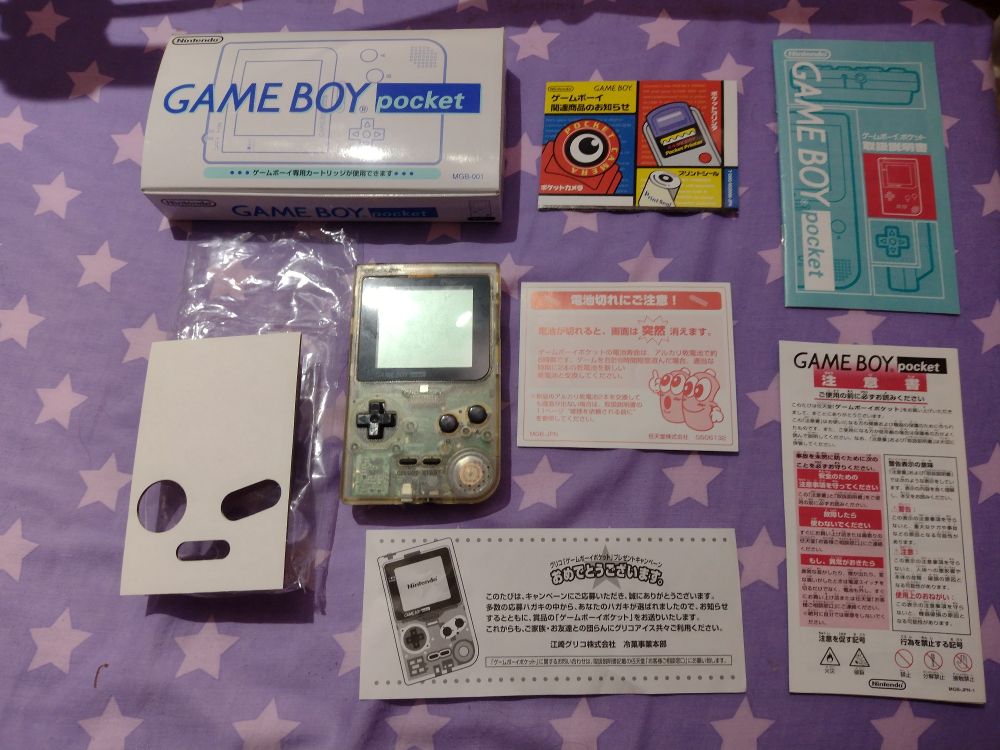 Glico clear gameboy pocket laid out with all of the manuals and letters 