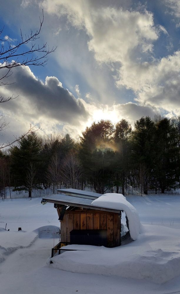 Cloud burst and blue sky.  An outbuilding in foreground.  Blue sky BlueSky