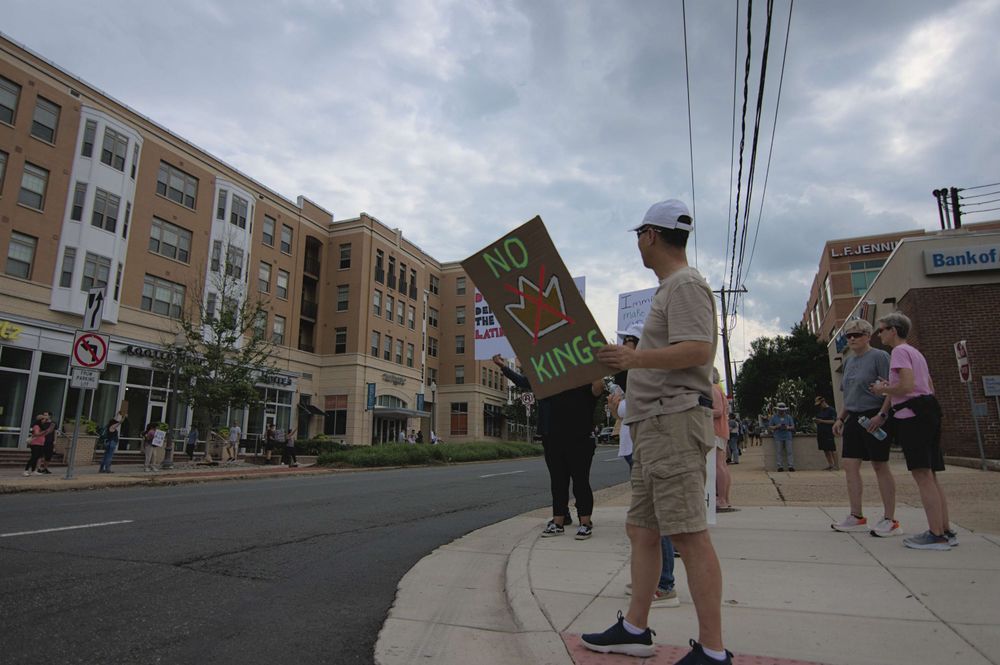 A peaceful protester holds up a sign with the theme of today's protest "NO KINGS"